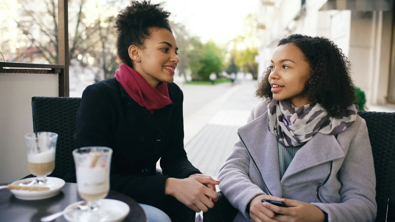 Deux amies discutent autour d’un café en terrasse